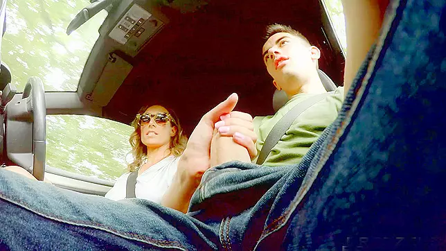 Ava Austen strokes hitchhiker Jordi's massive cock while driving the car