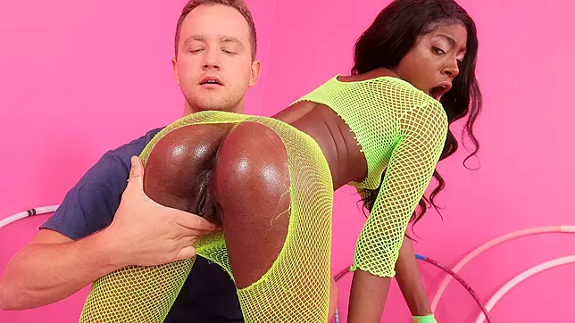 Anne Amari is practicing her hula-hooping skills in her neon fishnets, twirling and teasing the camera with her seductive curves